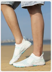 Outdoor shot of white and blue quick-dry water shoes on sand with breathable sport fabric
