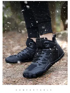 Detail of warm plush lining inside black winter barefoot hiking boots on pine needles