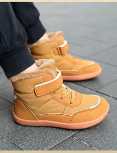 Detail of warm winter kids boot with plush lining, reflective strips and orange rubber sole