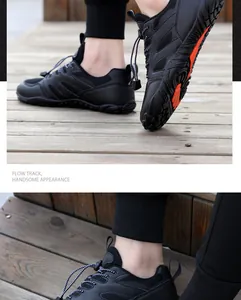 Detailweergave van de antislip rubberen zool met oranje noppen op zwarte outdoorschoenen