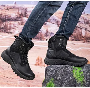 Detailed view of black tactical boots with side zipper on rugged outdoor terrain