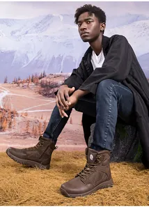 Detail of dark brown outdoor tactical boots with side zipper and rugged rubber sole