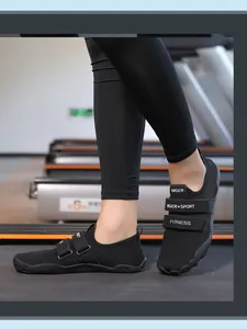 Primer plano de zapatillas de fitness negras de malla con doble velcro en una cinta de correr