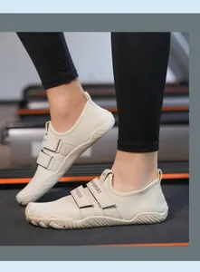 Vista lateral de zapatillas fitness barefoot beige con cierre de velcro en una cinta de correr