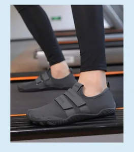 Detalle de zapatillas de deporte grises con velcro sobre una cinta de correr