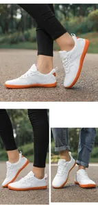 Detail of white mesh barefoot shoes featuring a vibrant orange non-slip rubber sole