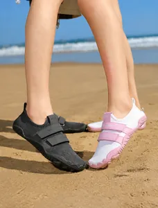 Primer plano de zapatos de agua transpirables con velcro doble en una playa de arena