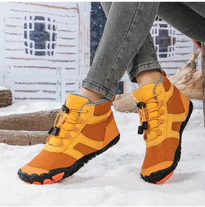 Outdoor snow boots detail showing orange waterproof fabric and fleece lining in the snow