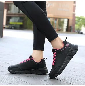 Dettaglio scarpa sportiva in pelle nera con lacci rosa e suola spessa antiscivolo