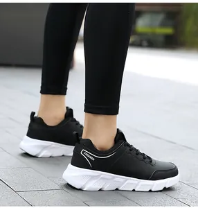 Vista laterale di scarpe sportive nere con scritte fashion e suola bianca spessa antiscivolo