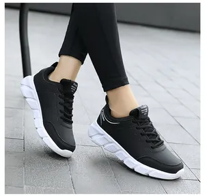 Dettaglio di scarpe sportive nere da donna in pelle con suola bianca spessa e antiscivolo