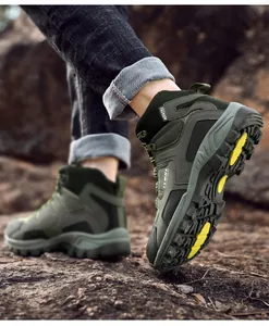 Detailed shot of army green hiking boots showing rubber outsoles on rocky outdoor terrain