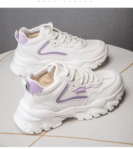 Detail of warm faux fur lining inside white platform sneakers with purple accents