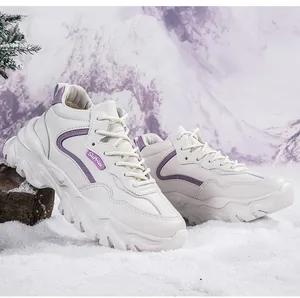 Close-up of beige winter sneakers with purple accents on a snowy outdoor background