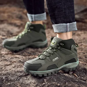 Men's olive green hiking boots with non-slip thick rubber soles on a rocky terrain