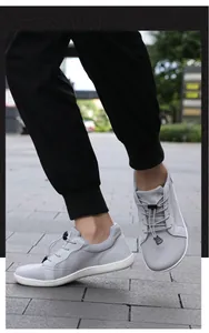 Detail eines grauen Barfußschuhs aus Mesh mit elastischen Schnürsenkeln und Gummisohle