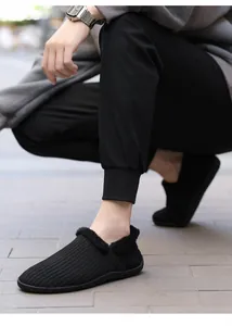 Detail of men's black knit thermal slippers with thick faux fur lining and soft texture