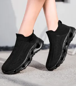 Detail of black breathable knit upper and wavy hollow platform sole on sock sneaker