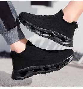 Close-up of black breathable knit sneakers with stylish hollow wave shock-absorbing soles
