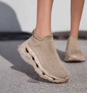 Close-up of beige breathable knit slip-on sneakers with textured mesh and thick hollow soles