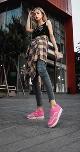 Close-up of pink breathable knit sneaker with thick sole on model in urban street setting