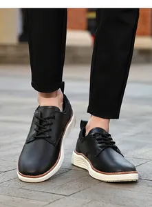 Close-up of black leather oxford shoes with thick white soles and brown trim detail