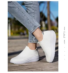 Detail of white flyknit slip-on sneakers with breathable mesh texture and thick soles