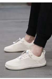 Detailed side view of beige barefoot training shoes with breathable mesh and elastic laces
