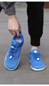 Detail of blue knitted barefoot sports shoes with elastic toggle laces and mesh texture