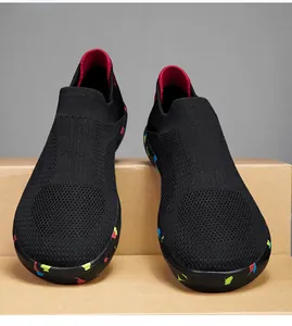 Detail of black knit walking shoe with breathable mesh and colorful paint splatter sole