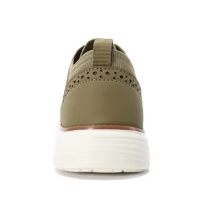 Detaillierte Rückansicht grüner Slipper mit klassischen Brogue-Lochmuster-Verzierungen