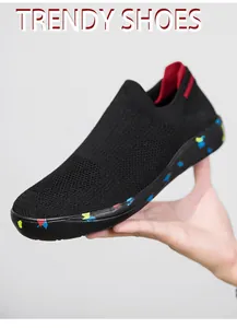 Macro shot of black slip-on walking shoe with breathable knit and colorful splattered sole