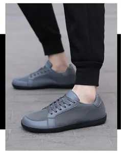 Zapatillas de deporte grises minimalistas con malla transpirable usadas en exteriores