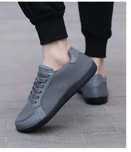 Vista exterior de calzado barefoot gris para hombre con malla transpirable sobre suelo