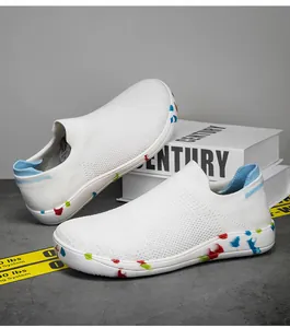 Detail of white flyknit slip-on sneaker featuring a colorful graffiti pattern on the sole