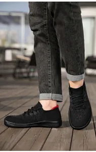 Detail of lightweight breathable flyknit men's sneakers with red decorative accents