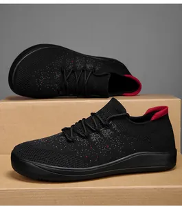 Detailed close-up of black breathable knit sneakers with red contrast heel and rubber sole