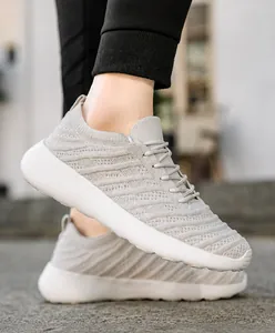 Gros plan de baskets en maille gris clair avec motif ondulé respirant et semelle épaisse