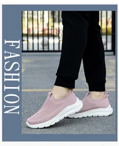 Vue portée de chaussures de marche roses en maille respirante avec semelle blanche