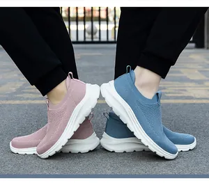 Gros plan de baskets à enfiler tricotées respirantes pour couples en rose et bleu dehors