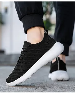 Détail de baskets en maille noire respirante pour hommes avec semelles blanches portées