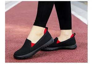 Vista en pista de zapatos de punto negro transpirable con detalles rojos y suela flexible