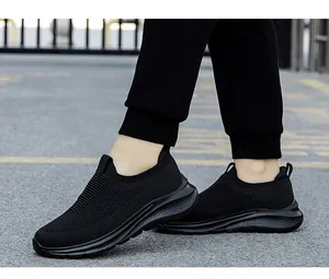Détail de baskets en maille noire respirante sans lacets avec semelles épaisses ondulées