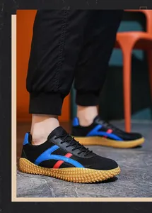 Detalle de zapatillas negras con rayas azul y rojo y suela de goma amarilla antideslizante