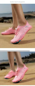 Detail of pink water shoe with quick-lace system and anti-slip sole on the sand