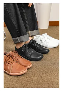Vista dettagliata di scarpe minimaliste in pelle a piedi nudi in marrone, nero e bianco