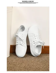 Vista macro di sneaker bianche in ecopelle con design basso stringato e targhetta fashion