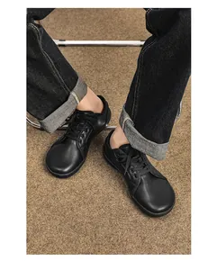 Vista dall'alto di scarpe casual a piedi nudi in pelle opaca nera con cuciture curate