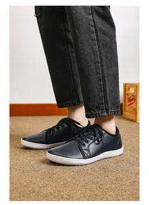 Vista laterale di sneakers casual in pelle sintetica blu scuro con suola in gomma bianca