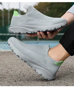 Detail of grey flyknit slip-on sneakers with breathable mesh and green heel pull tab